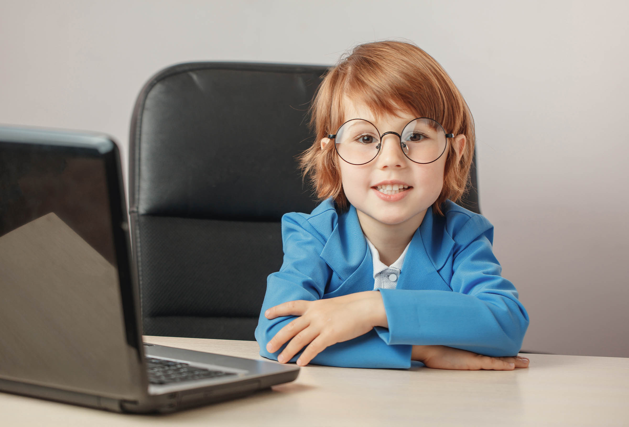 Litttle girl looking at laptop screen with expression of surprised and excitement. Smart, smilling little girl taking notes . Communication in business concept.